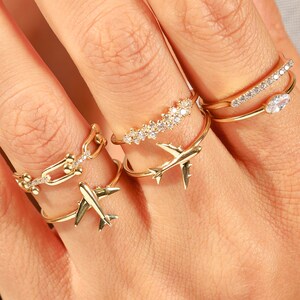 Celebrate your love for adventure with our traveler ring gold, a sleek and meaningful accessory for those always on the move. This stylish airplane ring 14K and Airplane ring gold design is perfect for any female pilot ring or aviation enthusiast. With its minimal plane ring design and elegant 18K stackable ring form, it's ideal for everyday wear. Whether you're looking for something gifted for hostess, travellers jewelry,