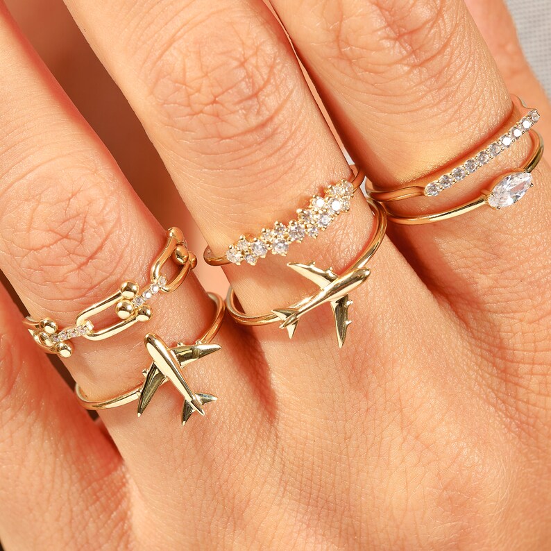 Celebrate your love for adventure with our traveler ring gold, a sleek and meaningful accessory for those always on the move. This stylish airplane ring 14K and Airplane ring gold design is perfect for any female pilot ring or aviation enthusiast. With its minimal plane ring design and elegant 18K stackable ring form, it's ideal for everyday wear. Whether you're looking for something gifted for hostess, travellers jewelry,