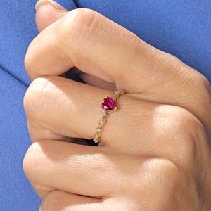 May include: A gold ring with a heart-shaped ruby gemstone and small diamonds set in a delicate band.