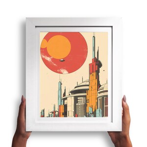 May include: A framed print depicting a futuristic cityscape with tall buildings and a large red planet in the background. The city is rendered in a retro style with a vintage colour palette.