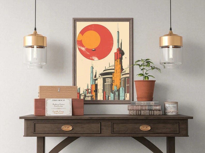 May include: A framed illustration of a futuristic city with a large red and orange planet in the background. The illustration is hanging on a wall above a wooden table with two drawers. There are two gold pendant lights hanging above the table, and a potted plant and a stack of books are on the table.