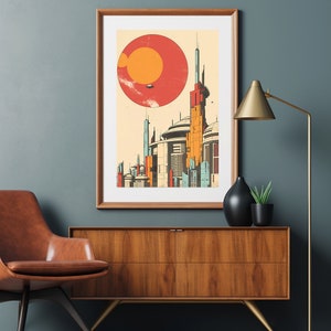 May include: A framed print depicting a futuristic cityscape with a large red sun in the background. The city features tall, slender buildings with geometric designs. The print is in a wooden frame and is hanging on a wall.