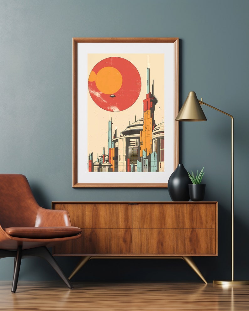 May include: A framed print depicting a futuristic cityscape with a large red sun in the background. The city features tall, slender buildings with geometric designs. The print is in a wooden frame and is hanging on a wall.