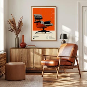 May include: An interior design scene featuring a framed poster of a mid-century modern chair against an orange background. A brown leather chair and a wooden cabinet with decorative vases are in the foreground. A small brown ottoman is in front of the cabinet.