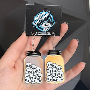 Pendientes de calavera de dibujos animados con diseño de esqueleto de hueso, de acrílico iridiscente, con un toque de color que cambia de color.