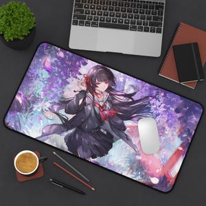 Puede incluir: Alfombrilla de ratón rectangular con una ilustración de estilo anime de una chica con uniforme escolar, pelo largo negro y ojos rojos. El fondo es un vibrante diseño floral púrpura. Se ve un ratón blanco y un portátil.