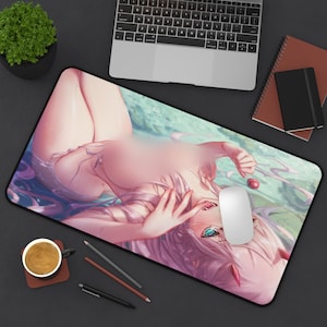 May include: Large rectangular mousepad featuring an anime-style illustration of a woman in a pool of water. The artwork has a pink and blue color scheme, with a white mouse and a cherry on the right side. A laptop, notebook, and coffee cup are also visible.