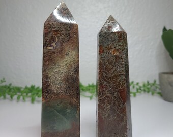 May include: Two brown, green, and silver agate crystal points. The points are polished and have a natural, organic look.