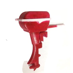 Könnte beinhalten: Ein rotes und weißes Spielzeug-Außenbordmotor aus Plastik. Der Motor hat einen Propeller und eine weiße Verkleidung.