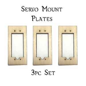 May include: A set of three wooden servo mount plates. The plates are light brown and have a rectangular shape with a cutout in the center. The plates are labeled "3PC SET".