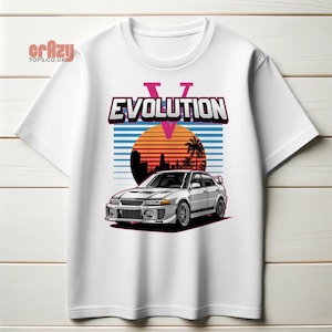 May include: White t-shirt featuring a graphic of a silver Mitsubishi Lancer Evolution V, a sunset, palm trees, and the text "EVOLUTION" in pink and blue.