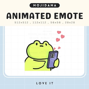 May include: Animated emote of a lime green frog using a purple smartphone, with three pink hearts above. The image includes the text "MOJIDAMA", "ANIMATED EMOTE", and "LOVE IT".