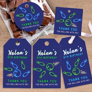May include: Blue and white thank you tags with a bowling ball and pins design. The text reads "Nolan's 8th Birthday" and "Thank you for rolling with me!"
