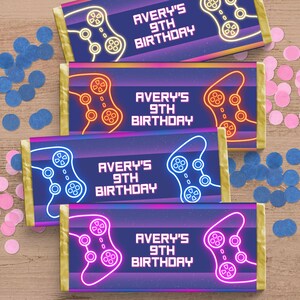 May include: Four printable chocolate bar wrappers with a neon blue, pink, and orange video game controller design. The text on the wrappers reads "Avery's 9th Birthday".