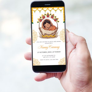 May include: A digital invitation for a baby naming ceremony. The invitation features a yellow, green, and red floral design with a baby in a basket. The text reads "You are invited to Anita and Anand's daughter's Naming Ceremony 17 October, 20XX | AT 9:00AM AT 123 Anywhere St.. ANY CITY, ST 12345 RSVP to Anita -123-456-7880"