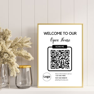 May include: A white sign with a gold frame that says "Welcome to our Open House" with a black and white QR code that says "Scan Me" below it. The sign also includes the text "More information call us +123-456-7890 Visit our website pikseltoprints.etsy.com".