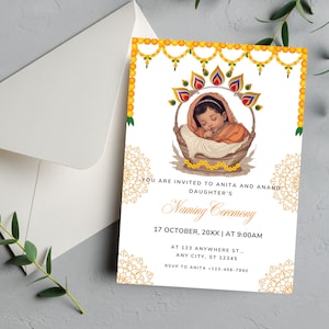 May include: A yellow and gold invitation card with a floral design. The card features a baby in a basket with a floral garland above. The text on the card reads "You are invited to Anita and Anand's Daughter's Naming Ceremony, 17 October, 20XX | At 9:00AM, At 123 Anywhere St., Any City, ST 12345, RSVP to Anita -123-456-7890".