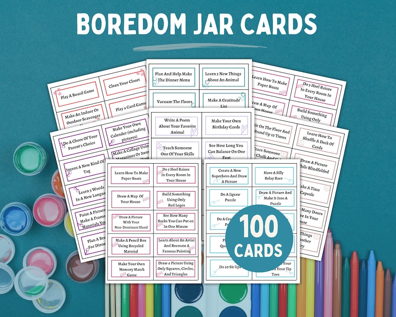 Eight pieces of paper with cards to be cut out for boredom jar ideas against a desk back drop with art supplies.
