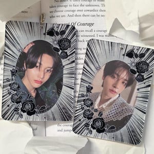May include: Two rectangular photo cards featuring portraits of a person. Each card has a black and white radial design around the oval portrait, with black rose accents. The cards are on a white surface with text.