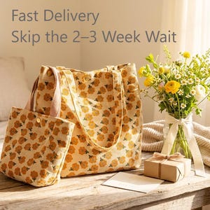 May include: A tote bag and small pouch set with a repeating floral pattern in shades of yellow and cream. The bags are on a wooden table, next to a bouquet of yellow and white flowers in a glass vase. The text "Fast Delivery Skip the 2-3 Week Wait" is at the top.