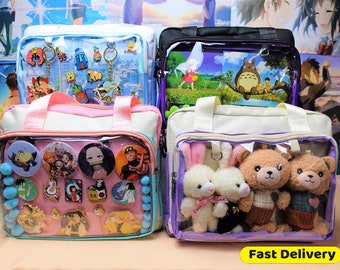Könnte beinhalten: Mehrere transparente Tragetaschen mit verschiedenen Gegenständen im Inneren. Eine Tasche hat Anstecknadeln und Knöpfe, eine andere Schlüsselanhänger und zwei weitere Stofftiere. Die Taschen haben unterschiedlich farbige Akzente und Griffe. Der Text "Fast Delivery" ist sichtbar.