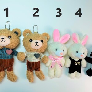 K&ouml;nnte beinhalten: F&uuml;nf Pl&uuml;sch-Schl&uuml;sselanh&auml;nger: zwei Teddyb&auml;ren, zwei Hasen und ein Panda. Die B&auml;ren haben Cordhosen und Pullover. Die Hasen haben rosa Ohren und Schleifen. Der Panda ist schwarz und wei&szlig;.