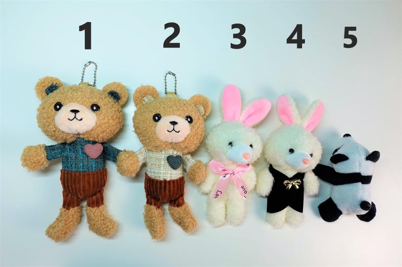K&ouml;nnte beinhalten: F&uuml;nf Pl&uuml;sch-Schl&uuml;sselanh&auml;nger: zwei Teddyb&auml;ren, zwei Hasen und ein Panda. Die B&auml;ren haben Cordhosen und Pullover. Die Hasen haben rosa Ohren und Schleifen. Der Panda ist schwarz und wei&szlig;.