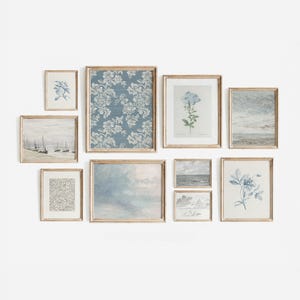 May include: A gallery wall of nine framed prints in a light wood frame. The prints feature a variety of subjects, including floral patterns, seascapes, and botanical illustrations. The prints are arranged in a staggered pattern, creating a visually appealing display.