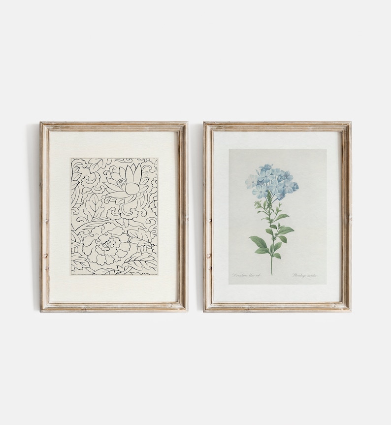 Puede incluir: Dos impresiones enmarcadas, una con un patr&oacute;n floral en blanco y negro y la otra con una pintura de acuarela de flores azules. Ambos marcos son de madera clara con un passe-partout blanco.