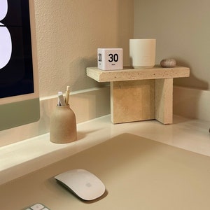 May include: A white desktop with a beige mouse pad, a white wireless keyboard with green keys, a white wireless mouse, a small beige ceramic vase with pencils, a white cube timer with the text "30 min", and a white ceramic candle on a beige stone shelf.