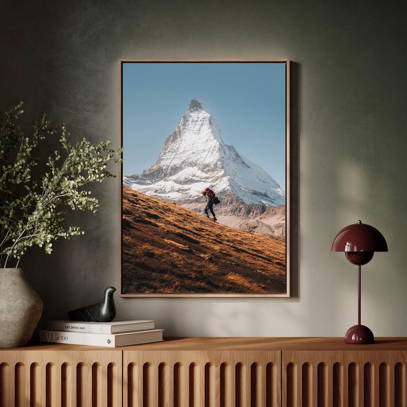 Elevate your home decor with this unframed Matterhorn wall art, encapsulating the essence of a solitary hikers journey in the Swiss Alps.