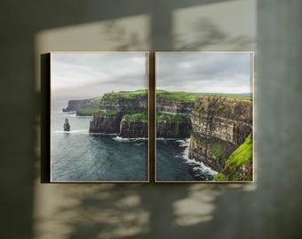 May include: Two framed photographs of the Cliffs of Moher in Ireland. The cliffs are tall and rocky, with green grass growing on top. The ocean is a deep blue, and the sky is cloudy.