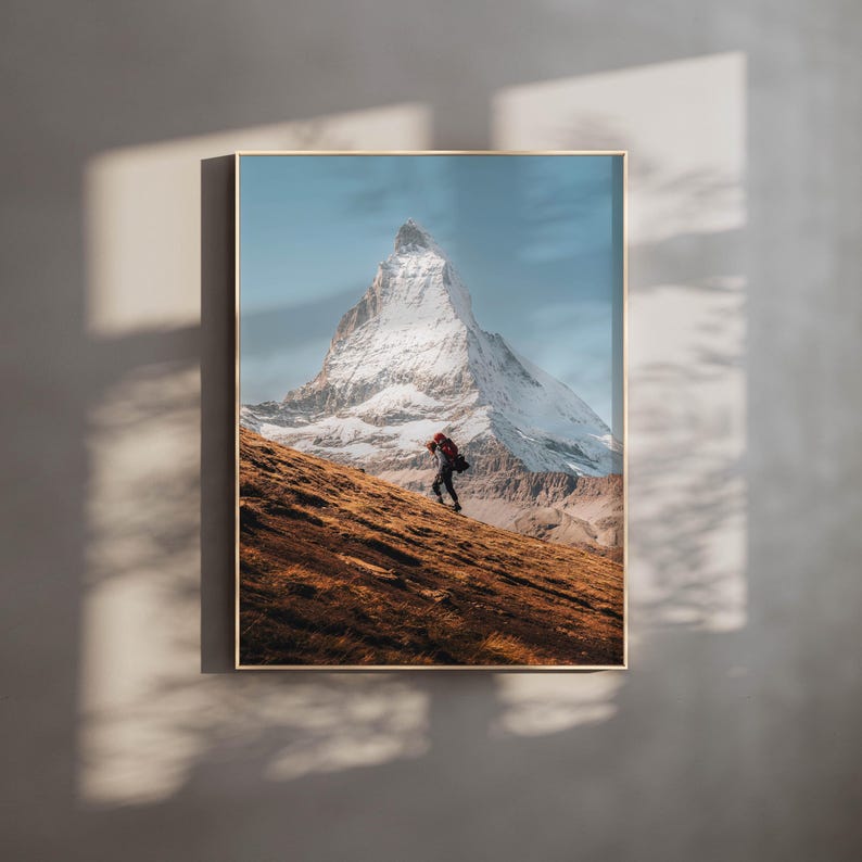 Experience the spirit of mountain exploration through this unframed print, showcasing a hiker against the breathtaking scenery of the Matterhorn