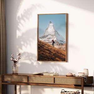 Transport yourself to tranquility with this unframed Matterhorn wall art, beautifully portraying a solitary trekkers contemplative journey.