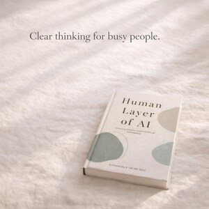 May include: A book titled "Human Layer of AI" with the subtitle "Thinking Clearly About Artificial Intelligence" is displayed on a white, textured surface. The cover features abstract shapes in muted green and beige, with the text "Clear thinking for busy people."