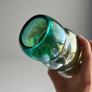 May include: A green glass bottle with a textured surface and a wide mouth opening.