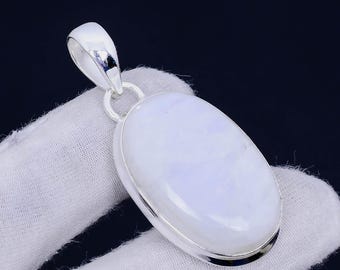 May include: A silver pendant with a large oval-shaped moonstone. The moonstone is a pale blue color with white swirls.