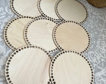 May include: Eight round wooden loom bases with holes around the edge. The bases are light brown and are stacked on top of each other.