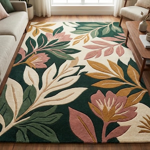 May include: A large rug with a botanical design. The rug features a dark green background with large, stylized leaves and flowers in shades of cream, pink, green, and gold. The rug is placed on a wooden floor.