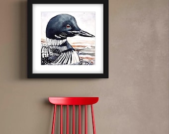 May include: A framed watercolor painting of a loon. The bird has a black head and neck, a white and black patterned body, and a long, dark beak. The loon is depicted in water with a neutral background. The frame is black.