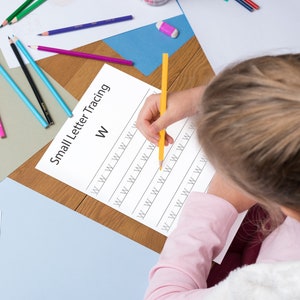 A kid is practicing small letter w handwriting for learning  in 1 page. A girl is tracing the lowercase alphabet w in 1 page for learning 26 capital letters for handwriting practice in 1 page, 26 small letters for handwriting practice in 1  page, along with 4 different uppercase and lowercase letters tracing & handwriting practice pages, respectively A,B & a, b alphabet tracing pages alphabet worksheets for kids toddlers activity book abc learning book tracing book ELA learning worksheets
