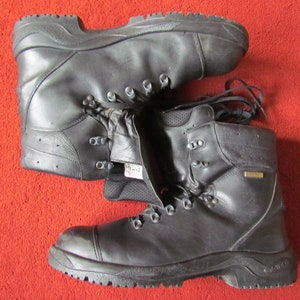 May include: A pair of black leather hiking boots with a lace-up closure and a Gore-Tex label. The boots have a thick rubber sole and a rugged design.