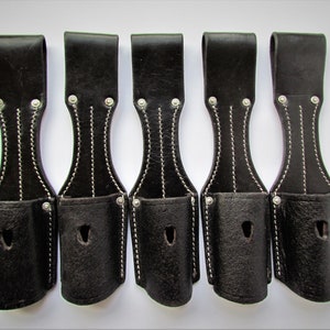 May include: Five black leather straps with white stitching and silver metal rivets. Each strap has a small pouch with a hole at the bottom.