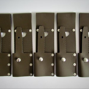 以下が含まれることがあります： 金属製の鋲と上部に金属製のループが付いた、茶色の革製のツールホルダーが5つあります。