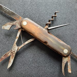 以下が含まれることがあります： 木製のハンドルが付いたヴィンテージマルチツールポケットナイフ。ブレード、ボトルオープナー、コルクスクリュー、はさみ付きです。