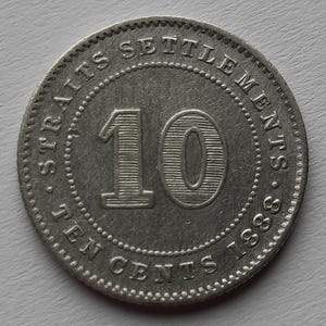 May include: A silver coin with the inscription "Straits Settlements Ten Cents 1888" and the number "10" in the centre.