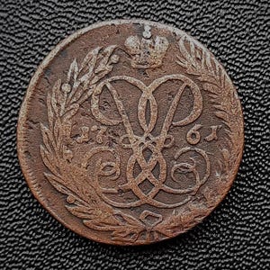 Könnte beinhalten: Eine Kupfermünze mit einer Krone und den kyrillischen Buchstaben "1761" auf der Vorderseite.