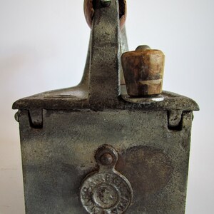 May include: A vintage cast iron flat iron with a wooden handle and a metal knob. The iron has a gray finish and is marked with the name "PATENTED".