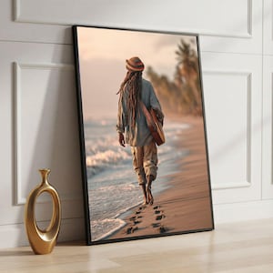 May include: Framed print of a person walking on a beach, carrying a guitar. The person has long dreadlocks and wears a hat. The image is set on a beach with palm trees and a golden vase in the foreground.