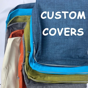 以下が含まれることがあります： 青、緑、オレンジ、グレー、ベージュなど、さまざまな色のカスタムカバーのスタック。各カバーにはジッパーとコントラストのあるトリムが付いています。「CUSTOM COVERS」の文字が白で印刷されています。